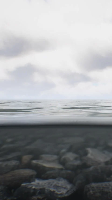 Water surface view on a cloudy day near rocky shoreline Stock Footage 346755525