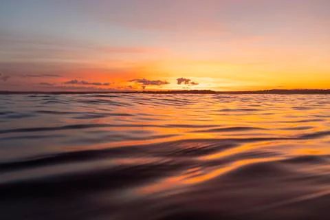 Water surface. View of a Sunset sky background. Dramatic gold sunset sky with Stock Photos