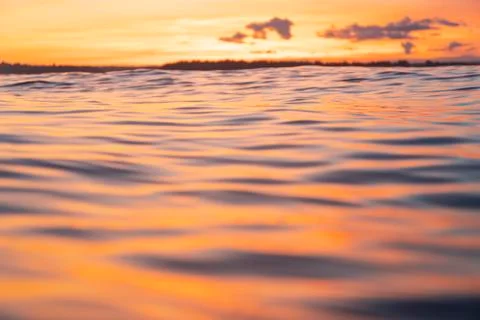 Water surface. View of a Sunset sky background. Dramatic gold sunset sky with Stock Photos