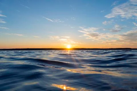Water surface. View of a Sunset sky background. Dramatic gold sunset sky with Stock Photos