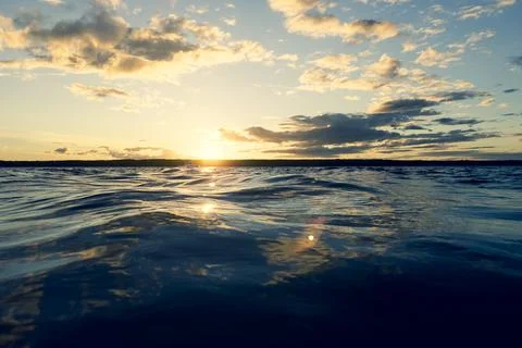 Water surface. View of a Sunset sky background. Dramatic gold sunset sky wi.. Stock Photos