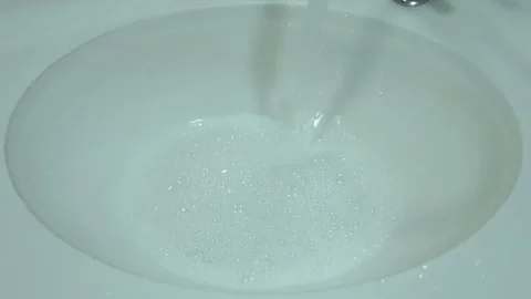 Water-swirling-draining-soapy-bathroom-sink-top-view Stock Footage 344944070