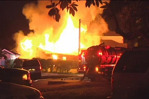 Water tanker waits outside large house fire Stock Footage