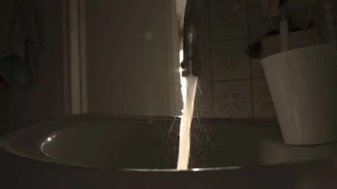 Water from the tap flows against the backdrop of the sunset. Water consumption 動画素材 317087849