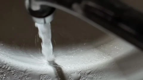 Water from the tap flows into the sink. Concept of tariffs and prices per cubic Stock Footage 318287990