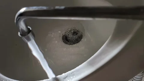 Water from the tap flows into the sink. Concept of tariffs and prices per cubic Stock Footage 322092907