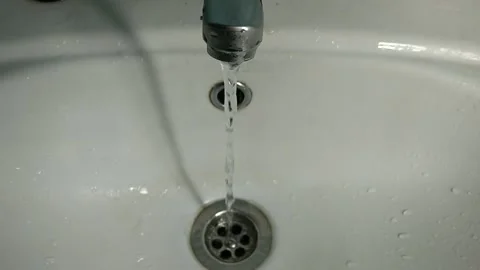 Water tap with running water that flows into a white ceramic sink Vídeo Stock 152178485