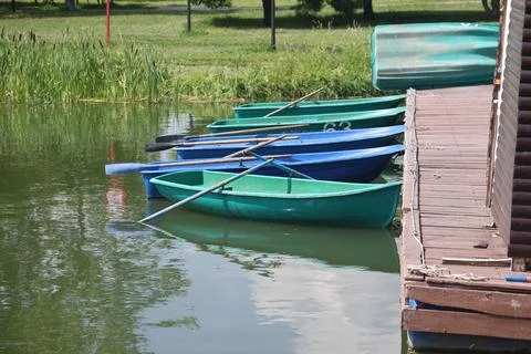 On the water there are multi-colored boats tied to the pier, pleasure boats.. Stock Photos