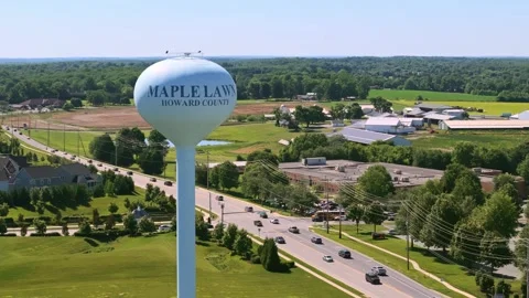 Water tower and traffic circle drone rising, rotating shot 70mm Maple Lawn, MD Stock Footage 336698486