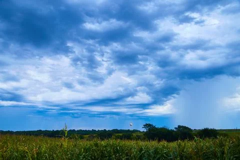 Water tower in stormy clouds with corn fields 스톡 사진