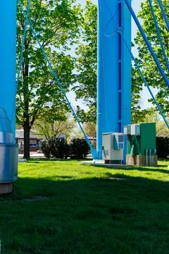 Water tower structure in a park setting with trees and utility boxes in bri.. Stock Photos