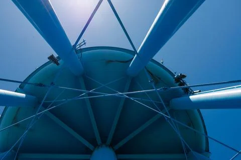 Water tower structure viewed from below with blue sky above and supporting .. Stock Photos