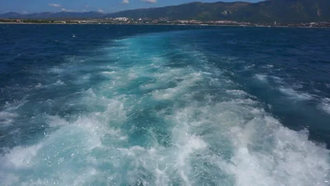 A water trail is formed using a boat. A water trail foams behind a boat sailing Stock Footage 116106304