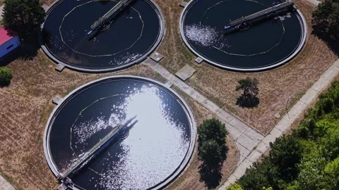 Water treatment facility with large round tanks seen from above Vidéo 343116655