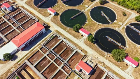 Water treatment facility operates in a planned layout with several tanks and Stock Footage 344255359