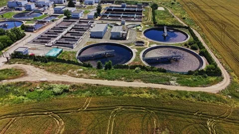 Water treatment facility processes waste in rural area during daytime Stock Footage 339059253