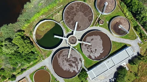 Water treatment facility processes wastewater in a community setting in daylight Stock Footage 337948570