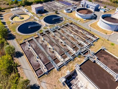 Water treatment facility processing wastewater at a large scale during daylig Stock Photos
