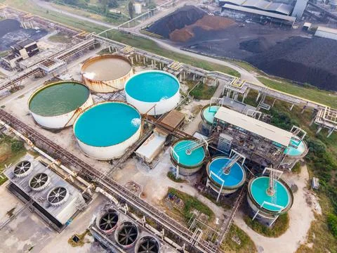 Water treatment facility shows multiple large circular tanks filled with diff Stock Photos