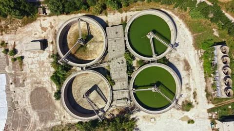 Water treatment facility shows three large circular tanks with different colored Stock Footage 340955046