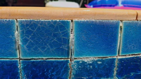 Water Trickle Flows Through Blue Ceramic Pool Tiles Into Rippling Water, Close U Stock Footage 345140673