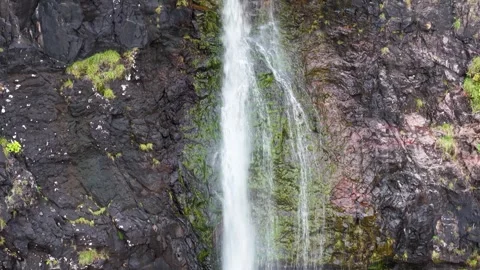 Water Tumbling Down Steep Black Volcanic Rock Face into Plunge Pool Stock Footage 346917236