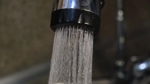 Water under pressure pours from a kitchen faucet. Stock Footage 329769593