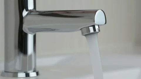 Water under strong pressure flows from a water tap Stock Footage 72497540