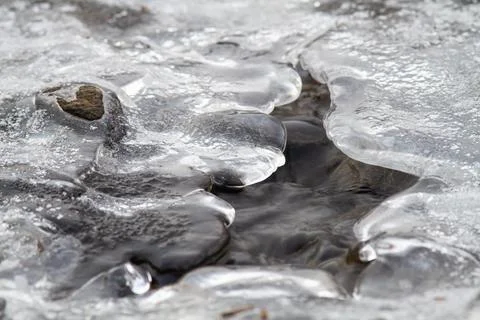 Water is visible under the eroded surface of the ice Stock Photos
