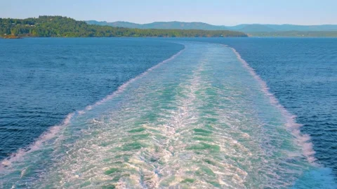 Water wake behind passenger ship navigating ocean coastal passage Stock Footage 342058385