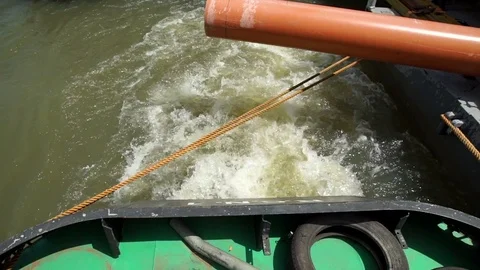 Water wake of the engine of a small boat towing a large floating platform. Stock Footage 71179180