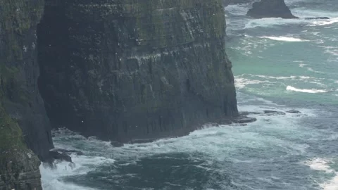 Water wave splashes against the bottom of the Cliffs of Moher Stock Footage 311757141