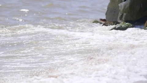 Water waves between stones on the sea beach Stock Footage 77566762