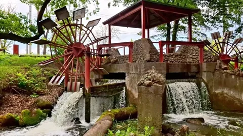Water Wheel Mill with Cascading Stream in a Peaceful Park Scene Stock Footage 337689693