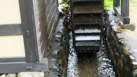 Water wheel spinning in the rain Stock Footage 243466928
