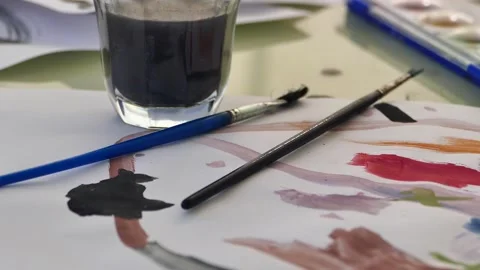 Watercolor work is done on a table, brush, paper and watercolor are on the ta 動画素材 187796112