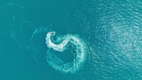 Watercraft makes sharp turn in bright blue ocean waters during sunny daytime Stock Footage 339517975