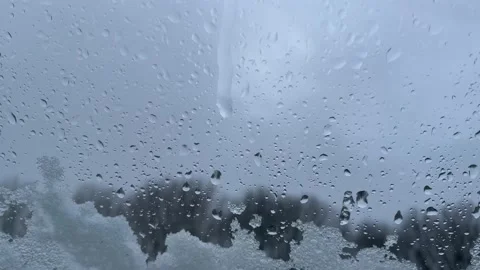 Waterdrop sliding down on window with ice crystals and snow Stock Footage 235526597