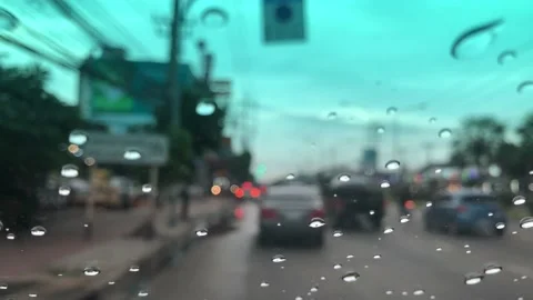 Waterdrops on car windshield, motion movement with traffic in the city on a rain Stock Footage 95027400