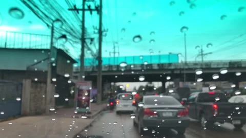 Waterdrops on car windshield, motion movement with traffic in the city on a rain Stock Footage 95027401