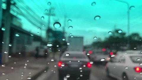 Waterdrops on car windshield, motion movement with traffic in the city on a rain Stock Footage 95027404