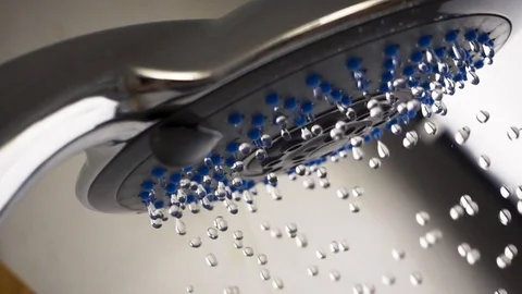 Waterdrops slowly falling from a shower head. Slow motion close-up shot Stock Footage 107086604