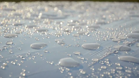 Waterdrops on white surface after rain reflect sun light Stock Footage 33071898