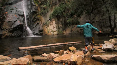 Waterfall 02 - Boy walking on rocks Stock Footage 1044455