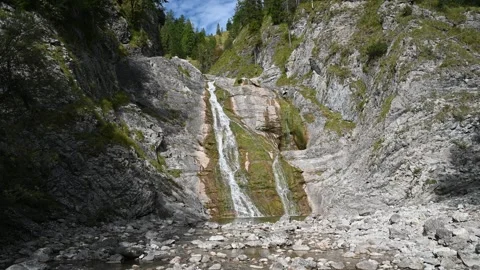 A waterfall in an alpine setting with trees and rocks Stock-Footage 260846142
