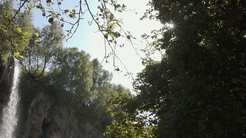 Waterfall among the greenery in the sun Stock Footage 82239114