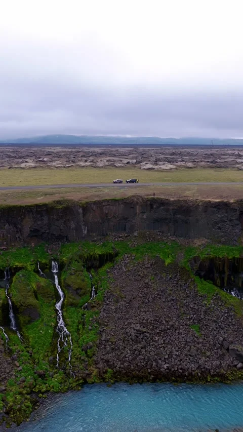 Waterfall and Basalt Cliffs Overlooking Iceland Lava Fields Stock Footage 341481484