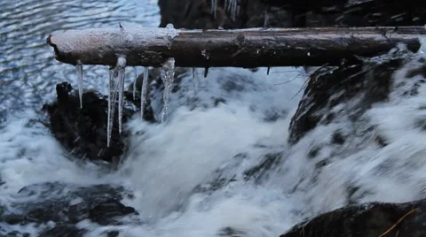 Waterfall and icicles on a log Stock Footage 40646687