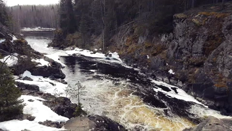 Waterfall and rapids on the forest river near rocks in winter time lapse Video stock 144074659