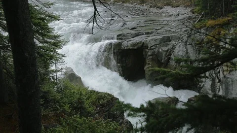 Waterfall and rapids in a forested valley in Alberta Video stock 91047063